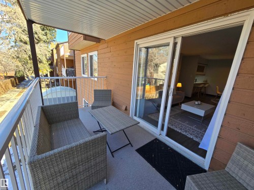 Outdoor balcony with a white metal railing, concrete flooring, and a corrugated metal ceiling - 202 24 Alpine Place, St. Albert, AB - Outdoor With Deck Patio Veranda With Exterior