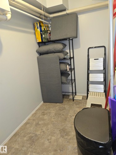 Utility space featuring light gray walls, an exposed ceiling with white piping, and neutral-toned square tile flooring - 202 24 Alpine Place, St. Albert, AB - Indoor