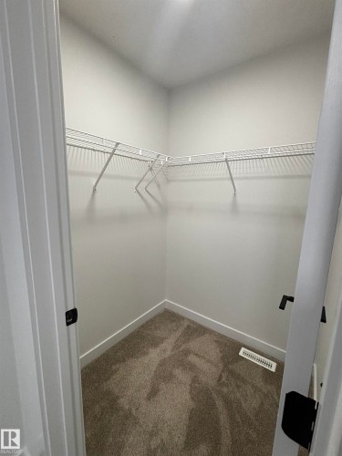 The property features a closet with carpeted flooring and white wire shelving - 2012 210 St, Edmonton, AB - Indoor With Storage