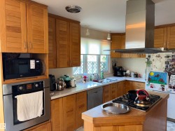 Hardwood kitchen cabinetry featuring integrated stainless steel appliances - 