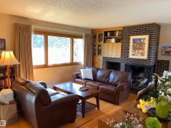 Hardwood flooring throughout featuring a brick fireplace with a built-in wood mantel and cabinetry - 