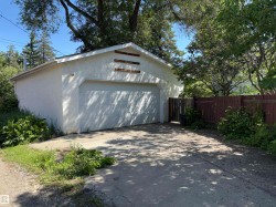 Detached garage with a paneled overhead door and stucco exterior finish - 