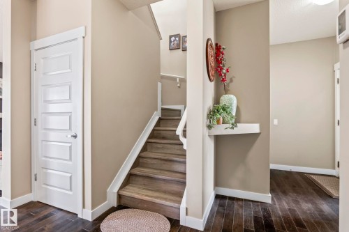 Staircase featuring wood-finish treads and white risers, framed by a matching white handrail - 8431 216 St Nw, Edmonton, AB - Indoor Photo Showing Other Room
