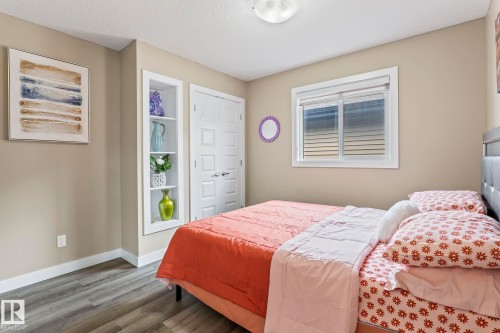 Bedroom featuring wood-finish flooring, neutral wall paint, and a built-in recessed shelving unit - 8431 216 St Nw, Edmonton, AB - Indoor Photo Showing Bedroom