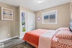 Bedroom featuring wood-finish flooring, neutral wall paint, and a built-in recessed shelving unit - 