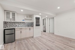 Wet bar featuring white cabinetry, hexagonal tile backsplash, and a compact refrigerator - 