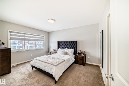 The property features light gray walls, a window with blinds, and a built-in ceiling light fixture - 2329 82 Street, Edmonton, AB - Indoor Photo Showing Bedroom
