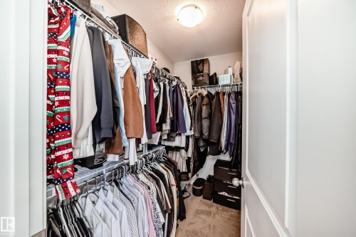 A spacious walk-in closet featuring wire shelving and hanging rods, with a ceiling light fixture providing illumination - 2329 82 Street, Edmonton, AB - Indoor With Storage