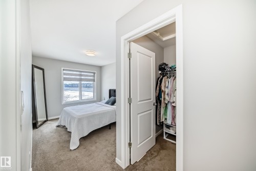 This room features a window with horizontal blinds, carpeted flooring, and a ceiling light fixture - 2329 82 Street, Edmonton, AB - Indoor Photo Showing Bedroom