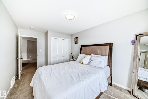 This bedroom features neutral-toned carpeting and light gray walls, creating a serene ambiance - 2329 82 Street, Edmonton, AB - Indoor Photo Showing Bedroom