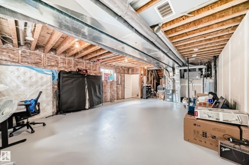 The property features an unfinished basement with exposed wooden joists and ductwork, providing a spacious area for potential customization - 2329 82 Street, Edmonton, AB - Indoor Photo Showing Basement