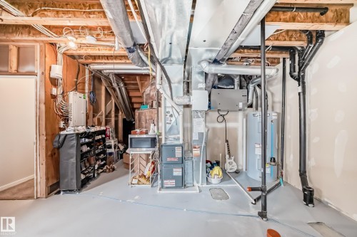 The property features an unfinished basement with exposed wooden joists and various utility installations - 2329 82 Street, Edmonton, AB - Indoor Photo Showing Basement