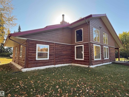 Log cabin exterior with a deep brown finish and white window frames - 63218 Range Road 254, Rural Westlock County, AB 
