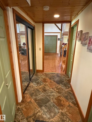 Entryway featuring multi-toned square floor tiles, natural wood trim, and a paneled wood ceiling - 63218 Range Road 254, Rural Westlock County, AB 