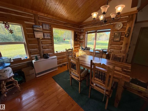 Dining area featuring log wall construction, natural wood-finish flooring, and a vaulted ceiling with exposed wood planks - 63218 Range Road 254, Rural Westlock County, AB 