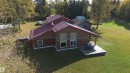 Exterior featuring a red metal roof, wood siding, and white-trimmed windows - 63218 Range Road 254, Rural Westlock County, AB 