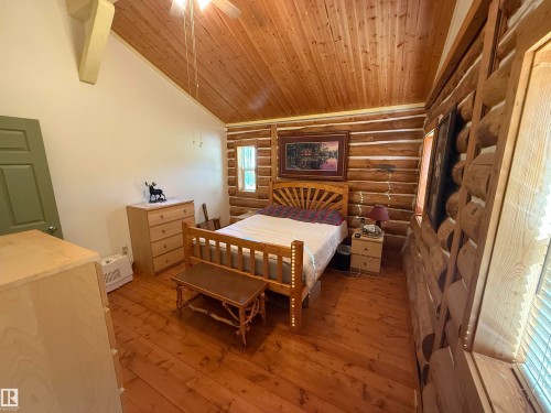 Interior room featuring log construction walls, wood-finish flooring, and a vaulted wood-paneled ceiling - 63218 Range Road 254, Rural Westlock County, AB 