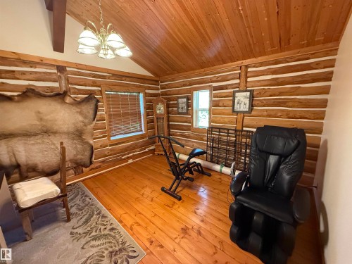 Room with exposed log walls, wood-finish flooring, and a vaulted wood-paneled ceiling - 63218 Range Road 254, Rural Westlock County, AB 
