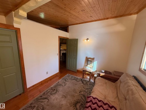 Interior space featuring wood-finish flooring, a wood plank ceiling, and light-colored walls - 63218 Range Road 254, Rural Westlock County, AB 