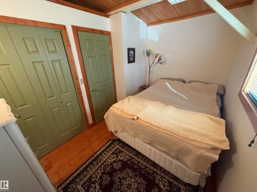 Attic space featuring an angled wood-paneled ceiling and exposed beam - 63218 Range Road 254, Rural Westlock County, AB 