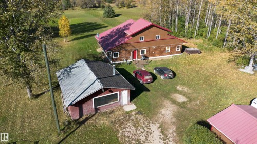 Log cabin-style main residence featuring a red roof and multiple windows - 63218 Range Road 254, Rural Westlock County, AB 