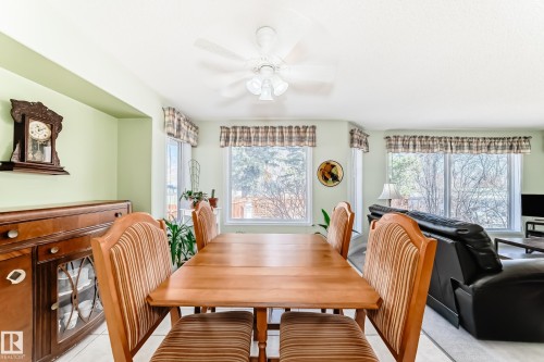 Bright dining space featuring a ceiling fan with integrated lighting, multiple windows, and light-toned wall finishes - 17 Springfield Crescent, St. Albert, AB - Indoor Photo Showing Dining Room