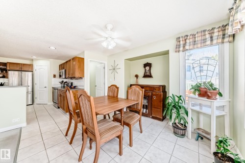 Kitchen and dining area featuring ceramic tile flooring, wood cabinetry, stainless steel appliances, and a ceiling fan with light fixture - 17 Springfield Crescent, St. Albert, AB - Indoor Photo Showing Dining Room