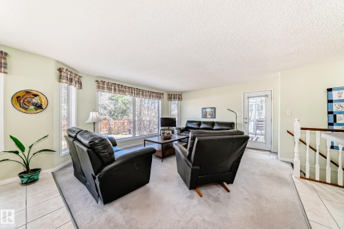 Bright living area featuring a large picture window, a glass-paneled exterior door, and light-toned wall finishes - 17 Springfield Crescent, St. Albert, AB - Indoor Photo Showing Other Room