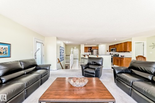 Open-concept living area with light-colored walls and carpet flooring - 17 Springfield Crescent, St. Albert, AB - Indoor Photo Showing Living Room