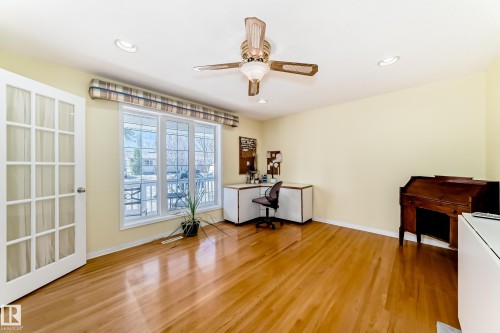 Hardwood flooring throughout this room, featuring a multi-pane glass door, recessed lighting, and a ceiling fan with light fixture - 17 Springfield Crescent, St. Albert, AB - Indoor Photo Showing Other Room