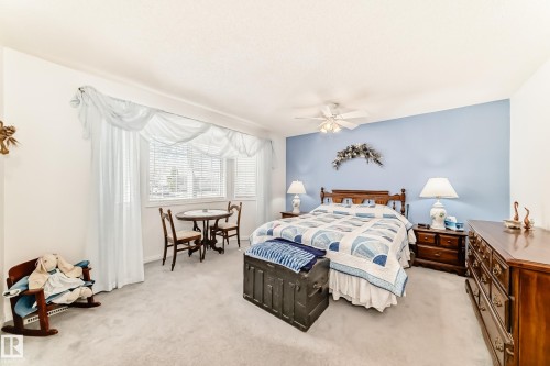 Carpeted bedroom with a window featuring horizontal blinds and sheer drapery - 17 Springfield Crescent, St. Albert, AB - Indoor Photo Showing Bedroom