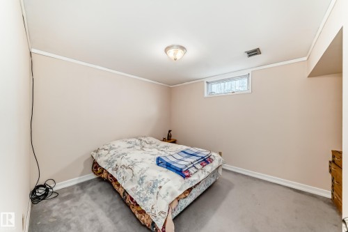 Carpeted room featuring a white-trimmed window, light-colored walls, and a ceiling-mounted light fixture - 17 Springfield Crescent, St. Albert, AB - Indoor Photo Showing Bedroom
