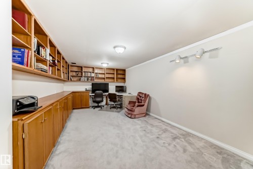 Dedicated room featuring extensive built-in wooden shelving, integrated cabinetry, and a continuous workstation - 17 Springfield Crescent, St. Albert, AB - Indoor