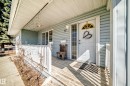 Covered porch with wood-finish decking, white railings, and siding exterior - 17 Springfield Crescent, St. Albert, AB  - Outdoor With Deck Patio Veranda With Exterior 
