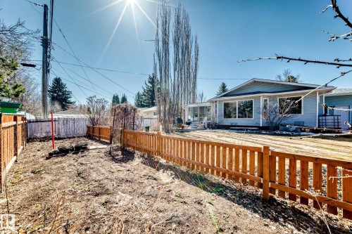 Expansive backyard featuring a new wood picket fence, a trellis structure, and mature trees - 17 Springfield Crescent, St. Albert, AB - Outdoor