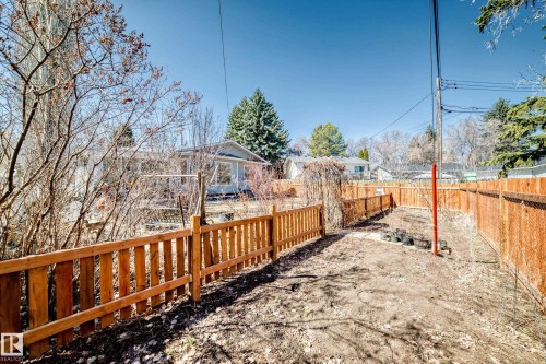 Rear yard area featuring newly installed wood fencing, a partial privacy fence, and mature trees - 17 Springfield Crescent, St. Albert, AB - Outdoor