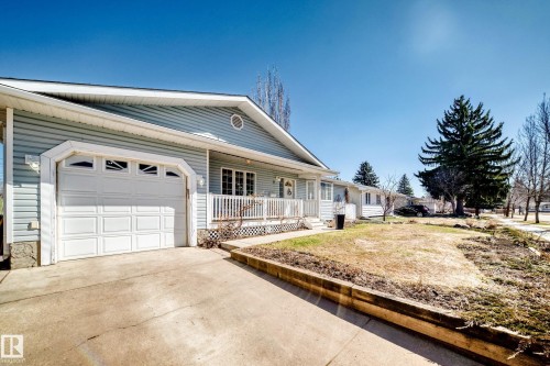 Light blue horizontal siding exterior with a single-car garage featuring decorative window inserts - 17 Springfield Crescent, St. Albert, AB - Outdoor With Deck Patio Veranda