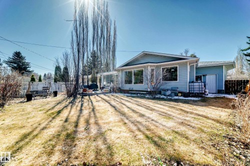 Expansive backyard featuring a manicured lawn and mature trees - 17 Springfield Crescent, St. Albert, AB - Outdoor