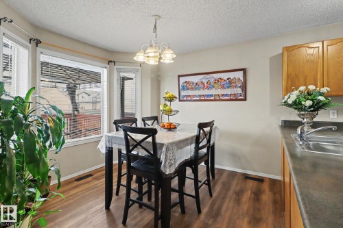 Dining area featuring wood-finish flooring and a multi-light chandelier - 11633 167B Avenue, Edmonton, AB - Indoor Photo Showing Dining Room