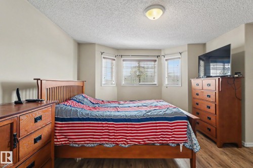 Room featuring a bay window with natural light, wood-finish flooring, and neutral wall tones - 11633 167B Avenue, Edmonton, AB - Indoor Photo Showing Bedroom