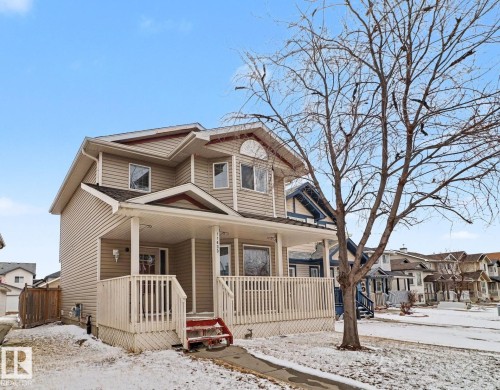 Two-story residence featuring light-colored siding and a covered front porch with white railings - 11633 167B Avenue, Edmonton, AB - Outdoor With Deck Patio Veranda With Facade