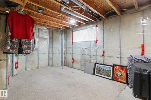 Unfinished basement space featuring exposed wood joists and subfloor, insulated walls, and a small window for natural light - 11633 167B Avenue, Edmonton, AB - Indoor Photo Showing Basement