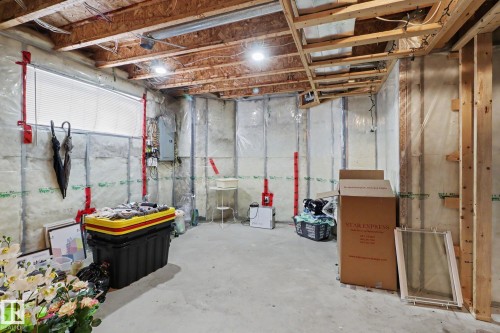 Unfinished basement space featuring exposed wood joists, concrete flooring, and a horizontal window with blinds - 11633 167B Avenue, Edmonton, AB - Indoor Photo Showing Basement