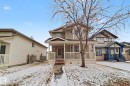 Two-story residence featuring light beige siding, a covered front porch with white railing, and a red-painted front entry door - 11633 167B Avenue, Edmonton, AB  - Outdoor With Deck Patio Veranda With Facade 