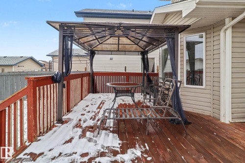 Expansive wood deck with a built-in gazebo featuring a dark metal frame and privacy curtains - 11633 167B Avenue, Edmonton, AB - Outdoor With Deck Patio Veranda With Exterior