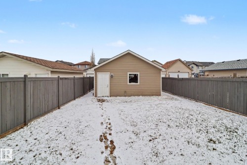 Detached garage with tan siding, a white service door, and a single window - 11633 167B Avenue, Edmonton, AB - Outdoor