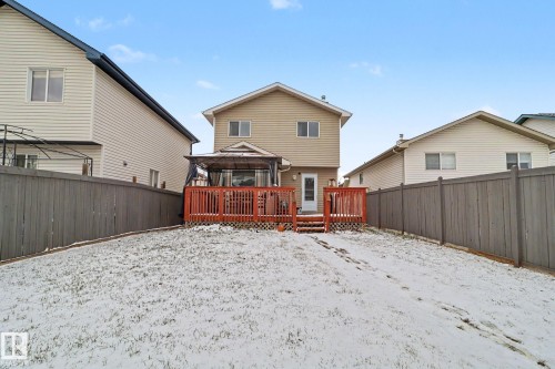 Rear exterior featuring a two-story residence with beige siding - 11633 167B Avenue, Edmonton, AB - Outdoor With Deck Patio Veranda With Exterior