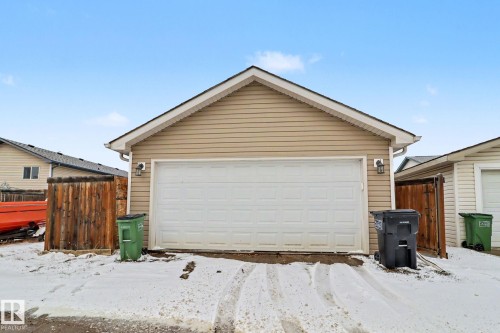Detached garage with horizontal vinyl siding and a white panel garage door - 11633 167B Avenue, Edmonton, AB - Outdoor With Exterior