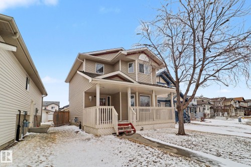 Two-story residential structure featuring light-colored horizontal siding and a covered front porch with white railings - 11633 167B Avenue, Edmonton, AB - Outdoor With Deck Patio Veranda