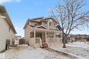 Two-story residential structure featuring light-colored horizontal siding and a covered front porch with white railings - 11633 167B Avenue, Edmonton, AB  - Outdoor With Deck Patio Veranda 